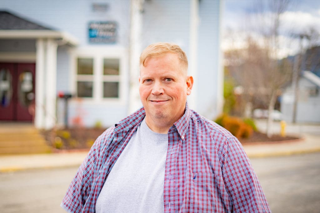 Mission Resident Aaron Stands in Front of Wagner Hall