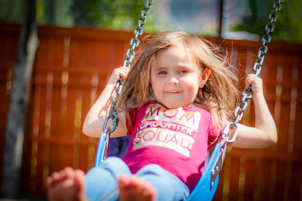 Child on the swing set at Fikso Family Center