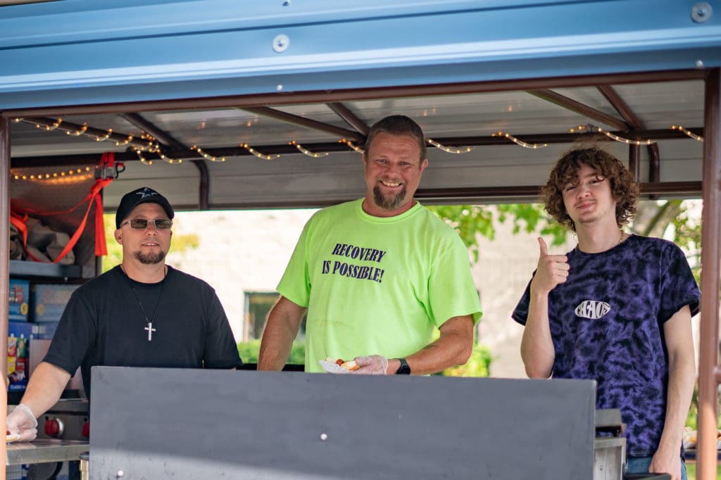 Men's Coordinator Bobby Galli serves hot dogs at the 2023 Recovery Fair