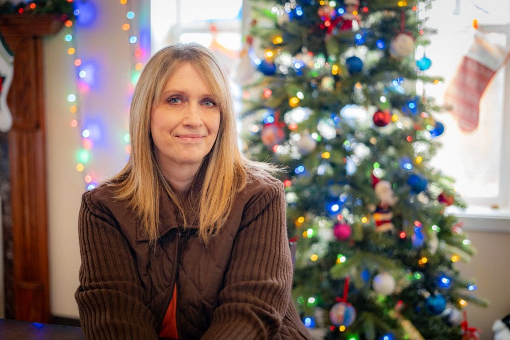 Resident Jennifer in front of a Christmas Tree