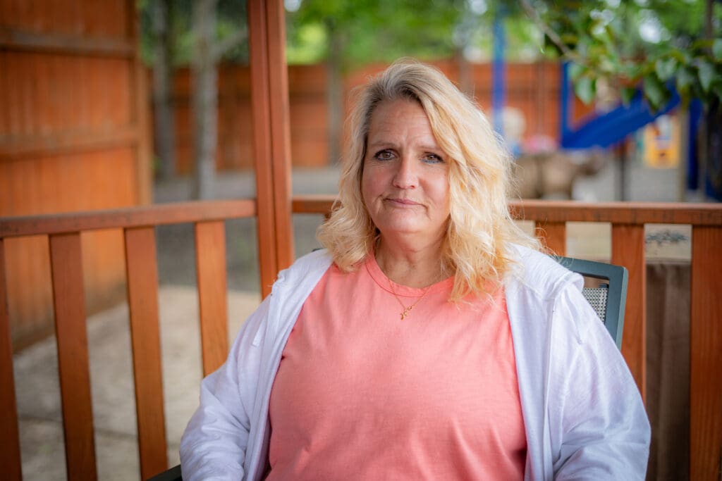 Elise sits in the back yard of Fikso Family Center